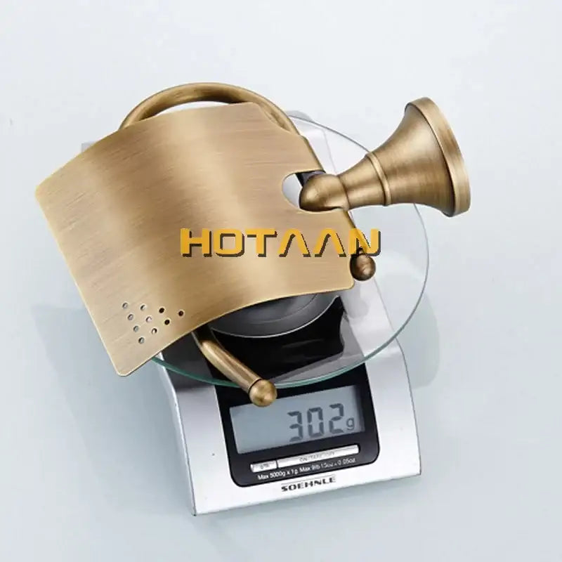 Antique brass curved toilet paper holder with a sleek brushed finish and decorative perforated design for bathroom use