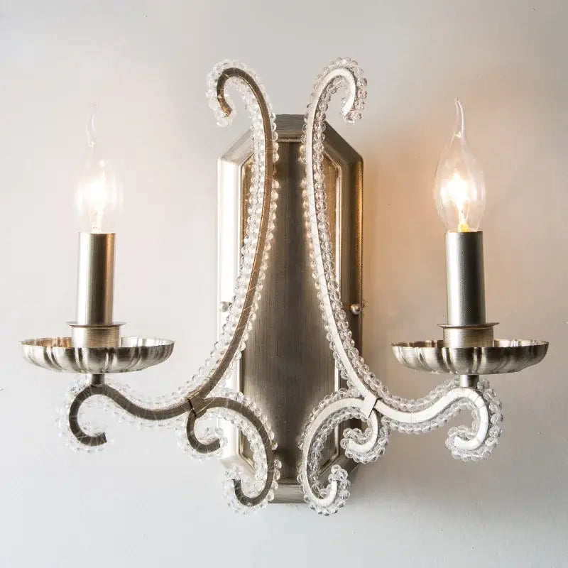 Silver-toned decorbites crystal led wall sconce with ornate crystal-encrusted arms and candle-style bulbs for living room lighting