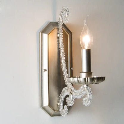 A silver-toned wall sconce with decorative clear glass beaded arm in an antique brass decorbites crystal led chandelier design