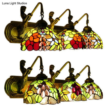 Lámpara de pared antigua de latón con cúpula, tres apliques de cristal de colores y diseño de hojas y flores.