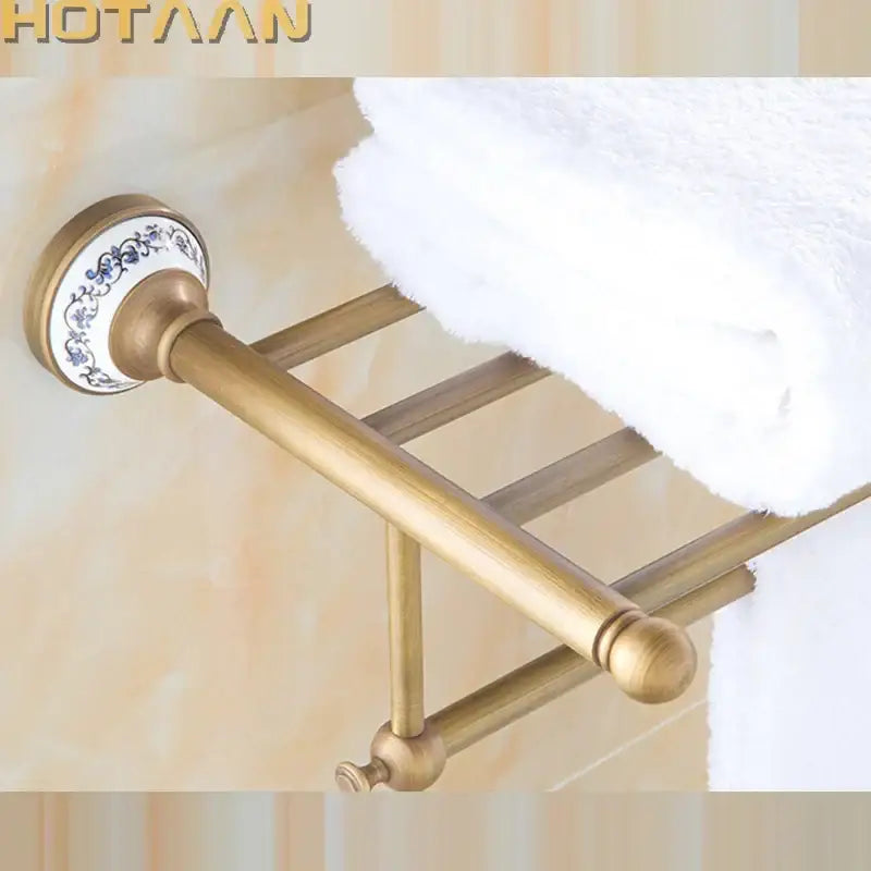 Antique brass double tier towel rack with a decorative blue floral ceramic towel holder for bathroom use