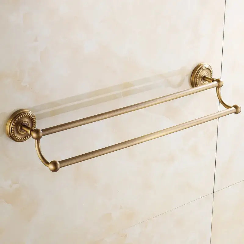 Antique brass double towel bar with ornate circular wall mounts and rounded end caps for bathroom use