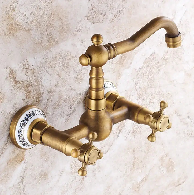 Antique brass dual handle kitchen faucet with hot water control, ornate cross handles, and porcelain plate escutcheons