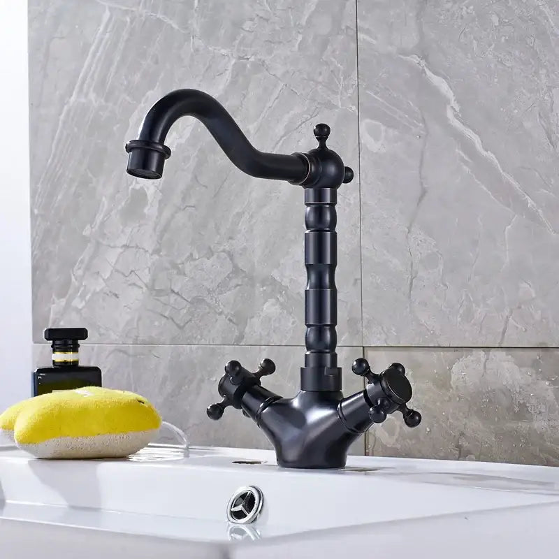 Antique brass dual handle swivel sink faucet in black matte brass with ornate vintage decorbites dual handle design