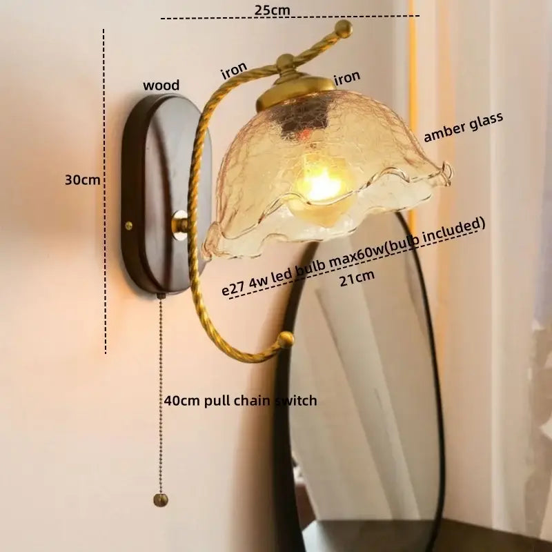 Antique brass floral led wall light with frosted amber glass shade and wooden backplate for bedroom sconce lighting