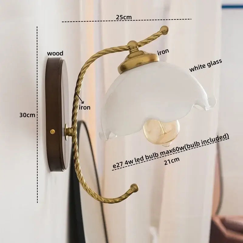 Antique brass floral led wall lights with twisted brass iron arm white glass shade and dark wood backplate for bedroom