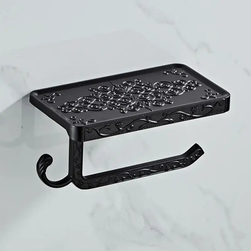 Black ornate metal toilet paper holder with intricate floral and scrollwork design for bathroom use