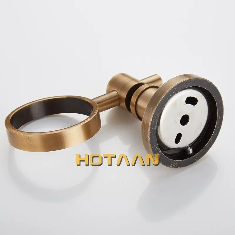 Antique brass floral soap dispenser holder with modern brass-finished bathroom faucet and circular spout base