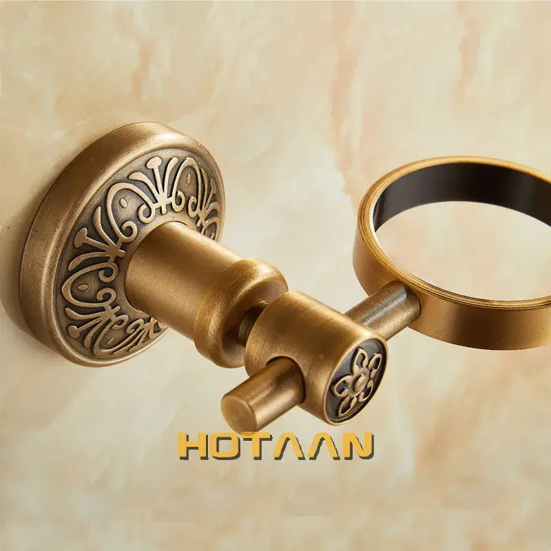 Antique brass floral towel ring with ornate engraving and matching dispenser holder for bathroom accessories