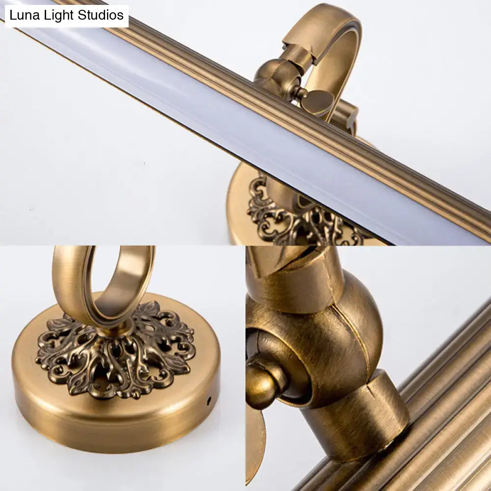 Antique brass floral vanity wall lamp with warm white light and ornate scrollwork detailing on the brass finish base