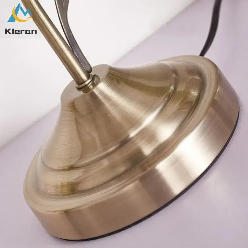 Antique brass glass flower led desk lamp with brass-finished conical tiered base and smooth metallic surface