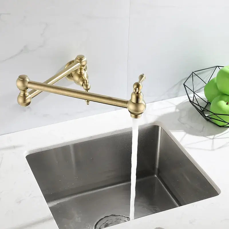 Antique brass gooseneck pot filler tap with ornate handles above stainless steel sink for kitchen use