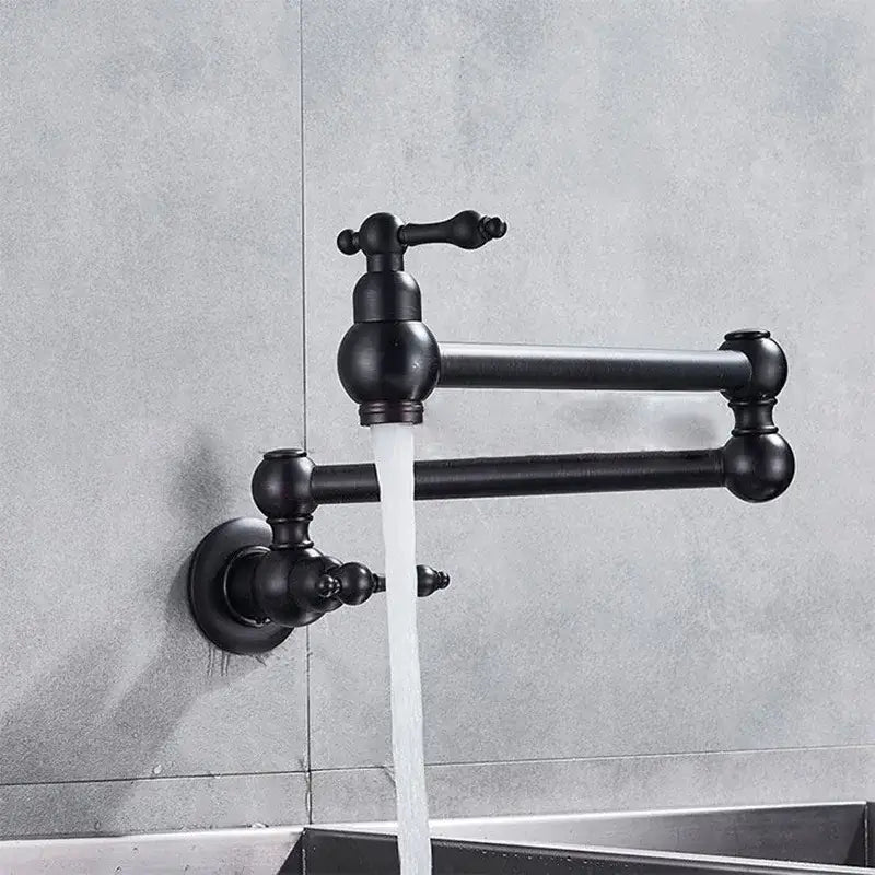 Black matte wall-mounted pot filler tap with articulated arms and ornate spherical detailing for kitchen use