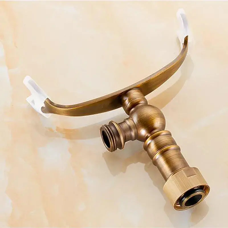 Antique brass hand shower holder hook with curved arched spout and two threaded connection points for shower holder