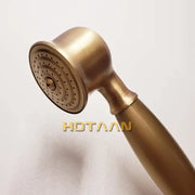 Antique brass handheld shower head with circular spray face featuring concentric rows of small perforations