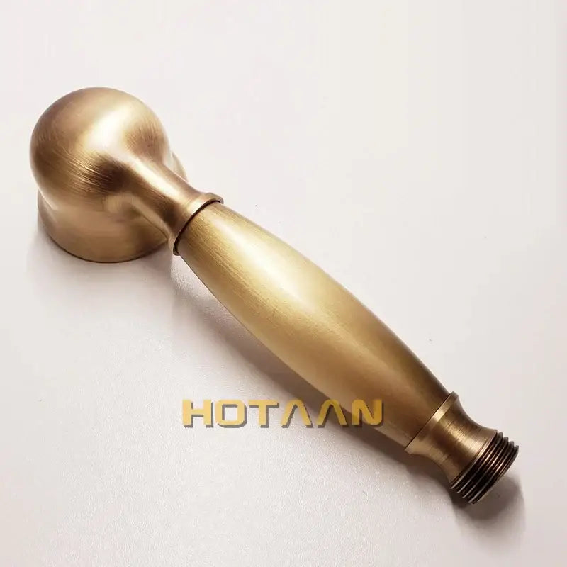 Antique brass handheld shower head with circular spray face and rounded spherical top with threaded base