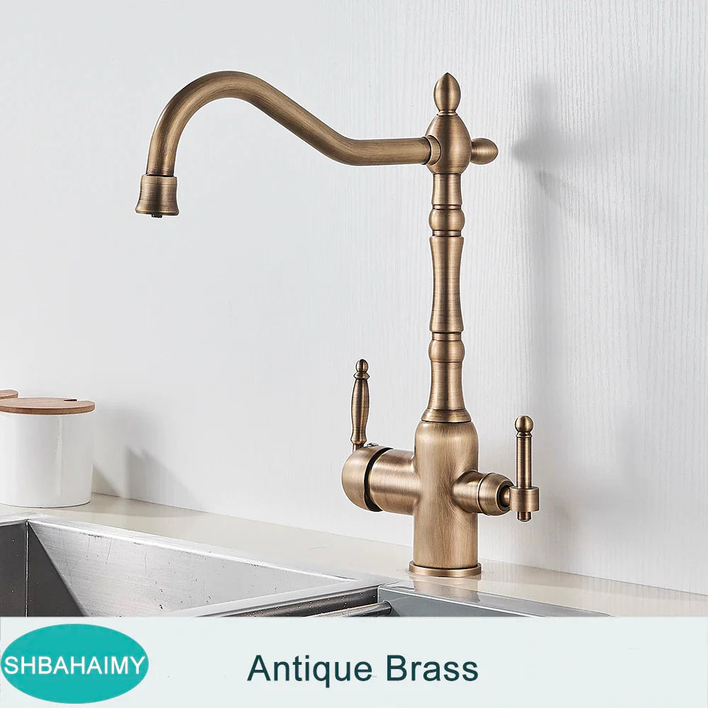 Antique brass kitchen faucet with dual handles and ornate vintage-inspired design featuring a curved spout