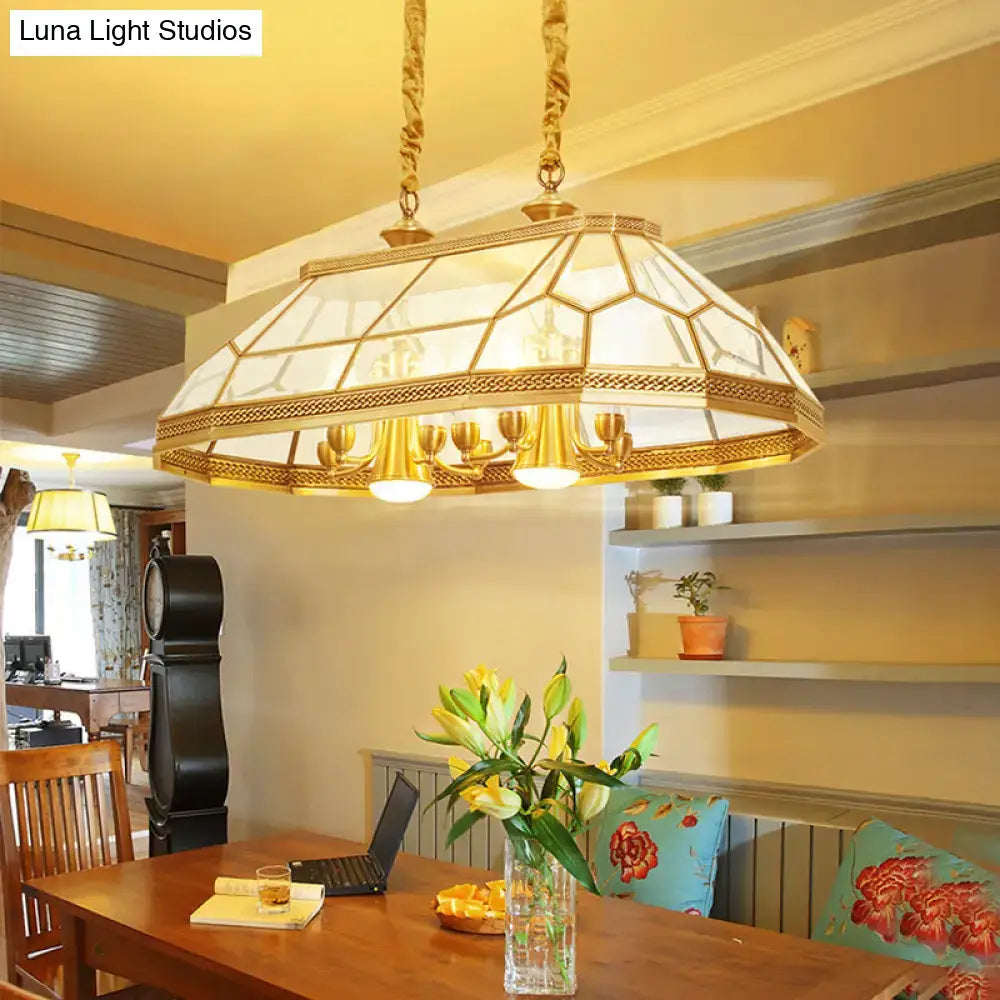 Gold-toned tiffany-style pendant light with geometric stained glass shade and ornate metalwork for faceted living room use