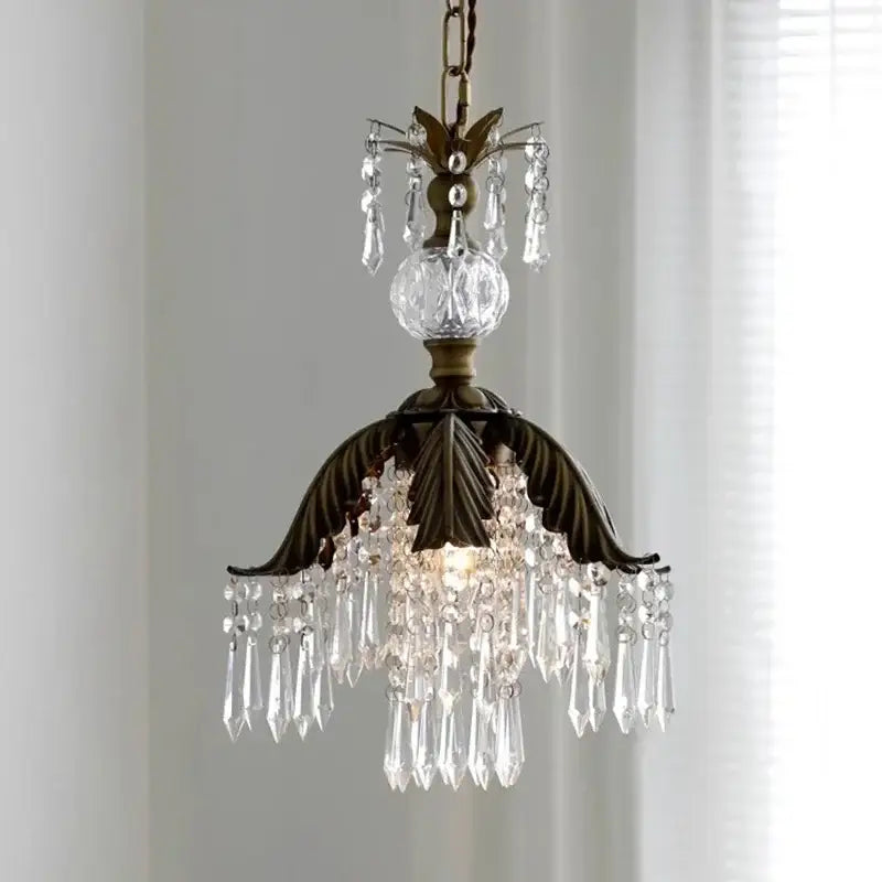 Antique brass leaf crystal pendant light featuring bronze leaf design with cascading clear prisms and faceted globe chandelier