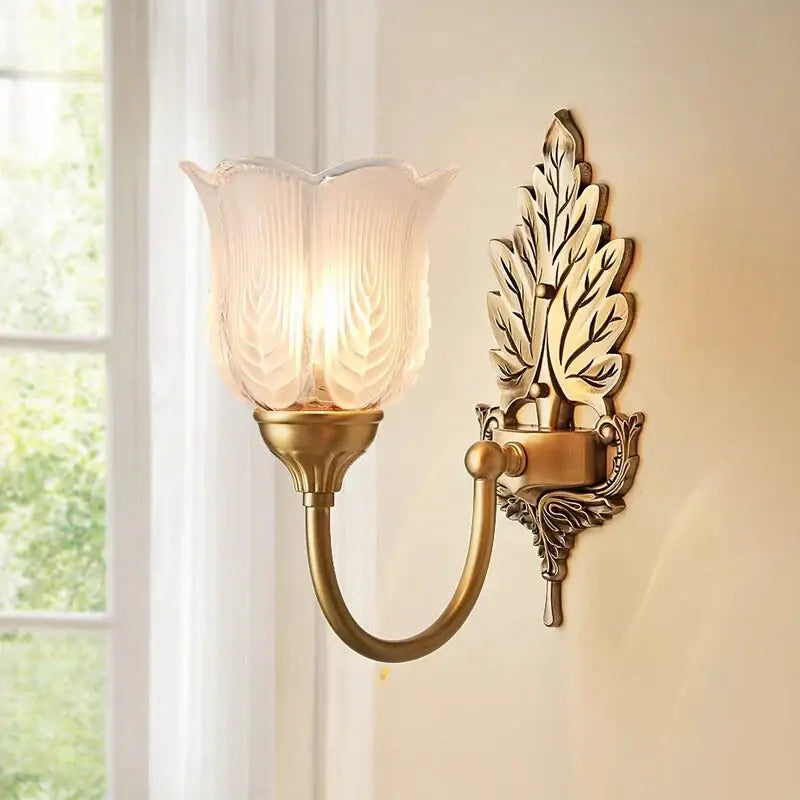 Antique brass leaf tulip wall lamp with frosted glass shade, a decorbites brass wall lamp ideal for bedroom lighting