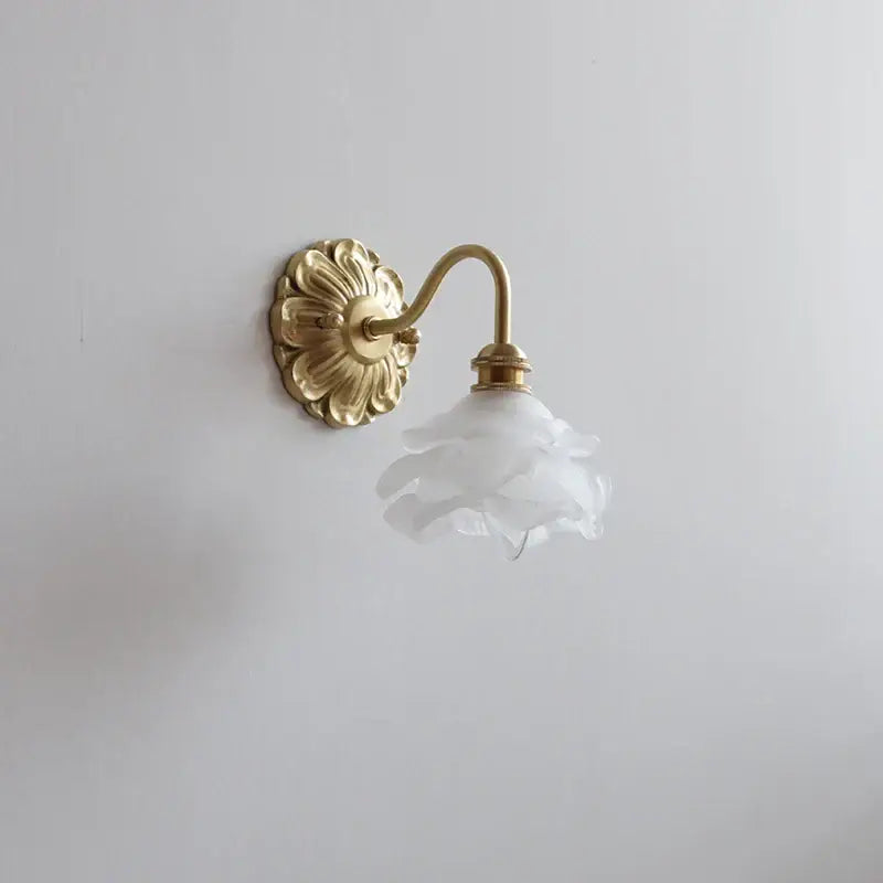 Delicate white frosted glass flower lampshade on antique brass wall lamp by decorbites for bedroom decor