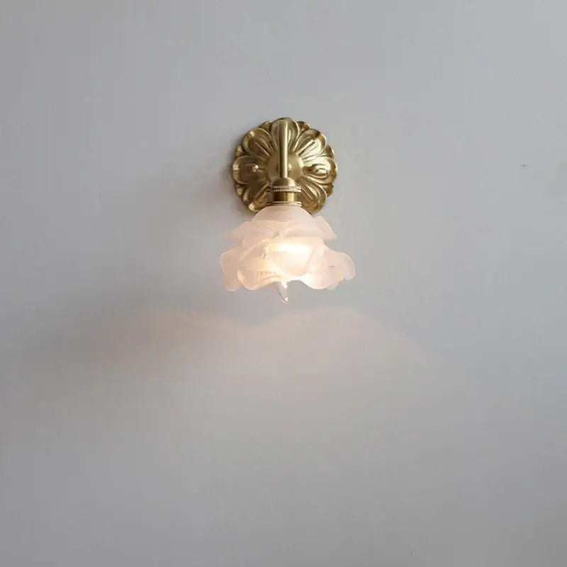 Antique brass wall lamp with a pink rose frosted glass shade by decorbites for elegant bedroom decor