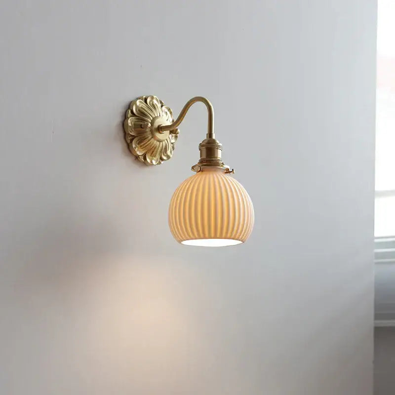 Antique brass wall lights with ribbed cream-colored glass shade featuring decorbites ceramic ball led design for bedroom use
