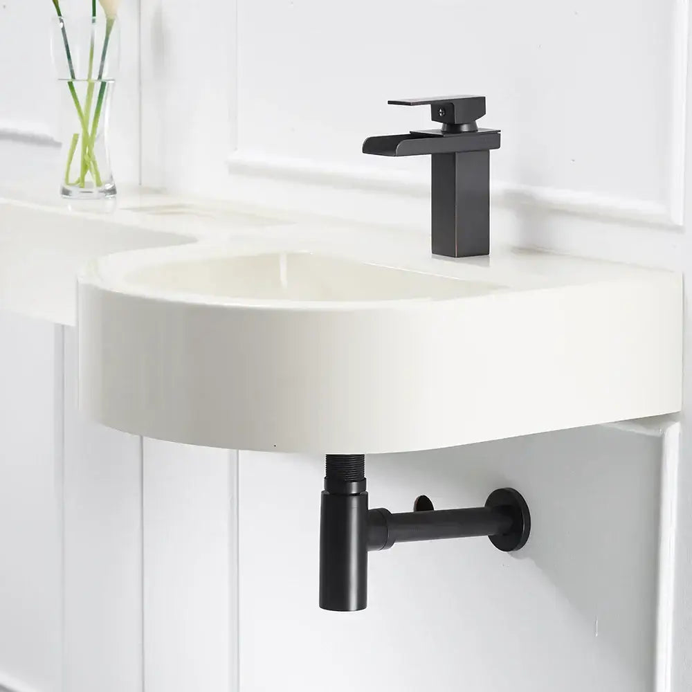 Modern black matte faucet with sleek rectangular spout on white sink paired with decorbites brass round bottle trap