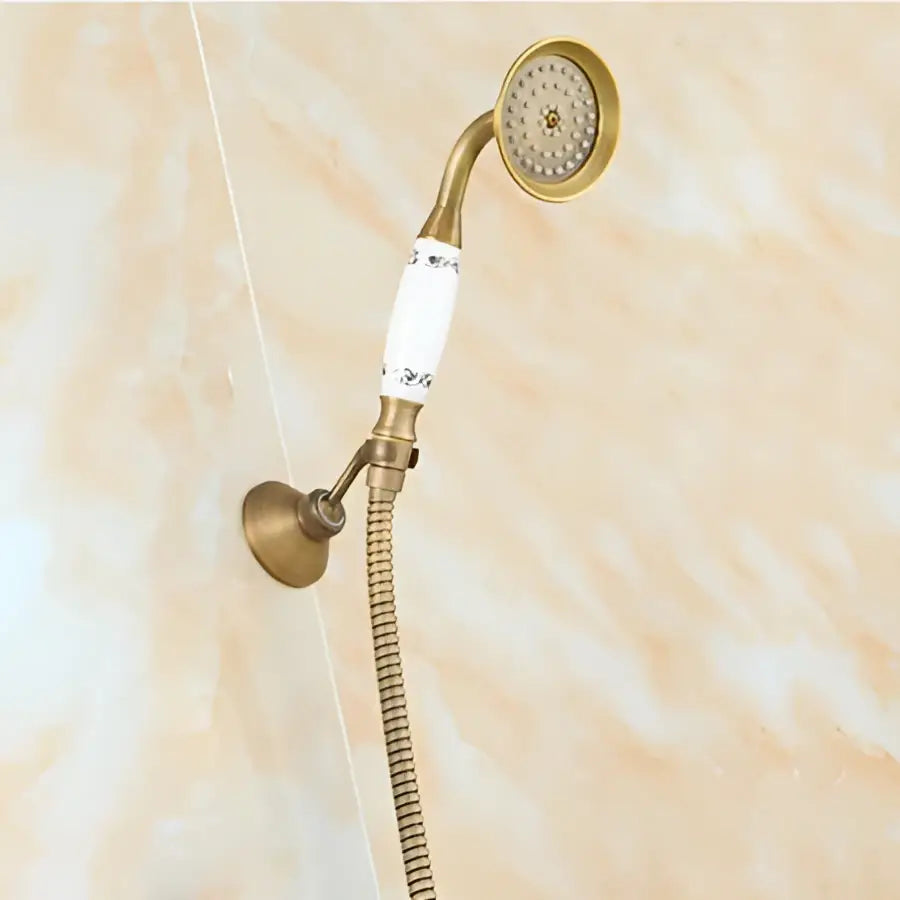 Antique brass round shower faucet set with brass handheld sprayer featuring white ceramic handle and flexible metal hose