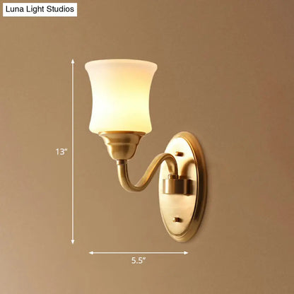 Aplique de pared de latón antiguo con pantalla curva de cristal color crema: ideal para decorar la pared de una escalera.