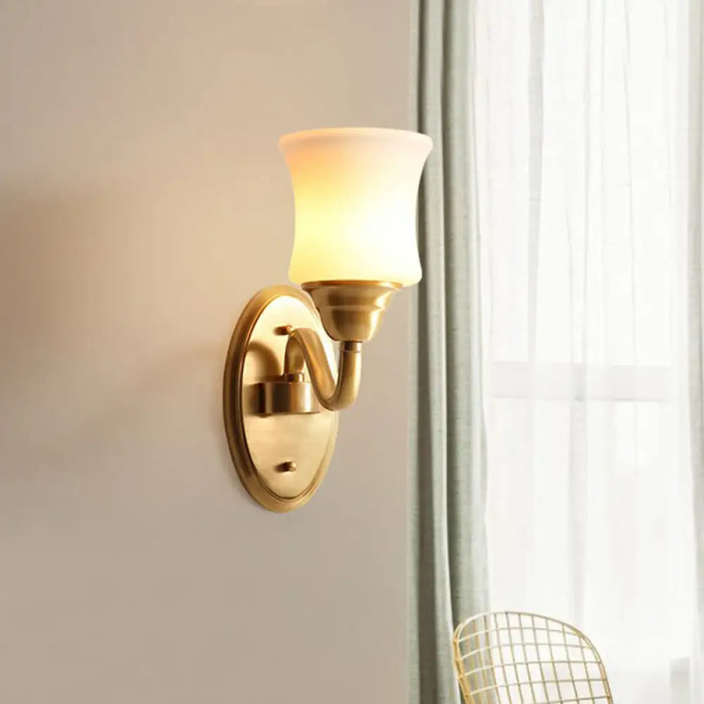 Aplique de pared de latón antiguo con pantalla curva de cristal color crema: ideal para decorar la pared de una escalera.