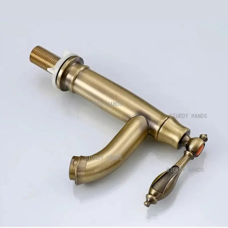 Antique brass single handle bathroom faucet with curved spout and ornate handle design for bathroom sink fixture