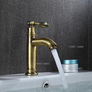Antique brass single-handle bathroom faucet with classic design and flowing spout for bathroom sink fixture