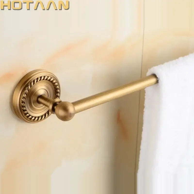 Antique brass single towel bar with ornate circular base and spherical finial for elegant bathroom decor