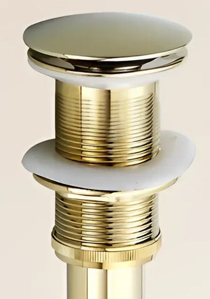 Antique brass decorbites brass sink drain stopper with white rubber seal and gold-toned polished finish and ridged threading