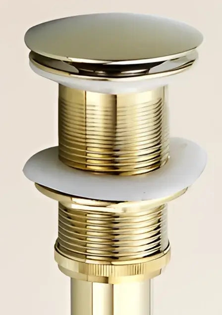 Antique brass decorbites brass sink drain stopper with white rubber seal and gold-toned polished finish and ridged threading