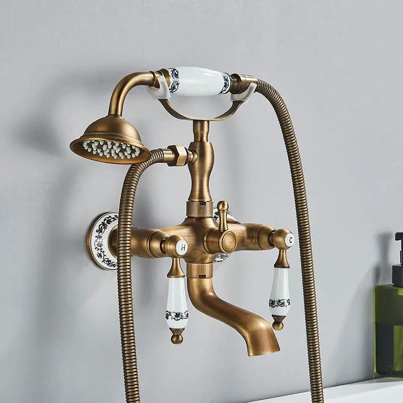 Antique brass dual handle bathtub faucet with white ceramic handles black floral patterns and matching showerhead decorbites dual handle