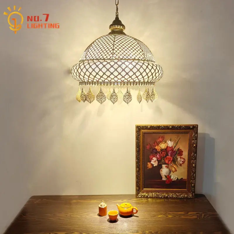Antique brass gold lustre iron pendant light with ornate lattice design and dangling charms for dining room decorbites pendant lights