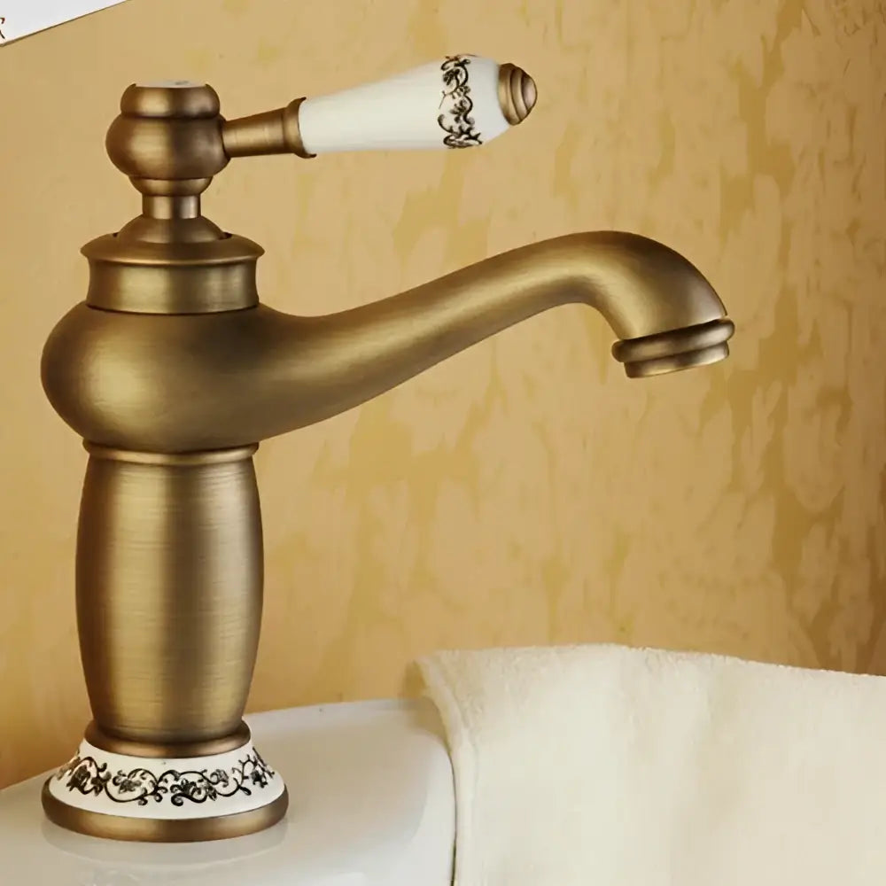 Antique bronze DecorBites™ single handle bathroom faucet with brass finish and white ceramic base with black floral patterns real shot details