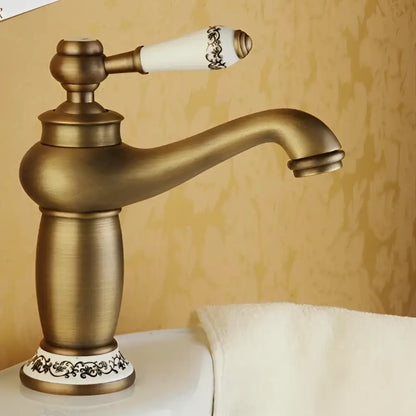 Antique bronze DecorBites™ single handle bathroom faucet with brass finish and white ceramic base with black floral patterns real shot details