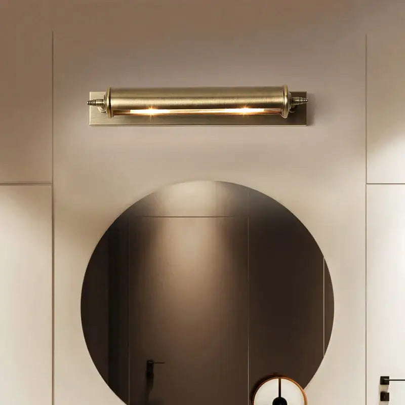 A sleek antique bronze bathroom wall lamp with brushed brass cylindrical design and warm glow for decorbites bronze bathroom decor