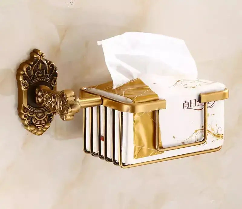 Gold-toned ornate wall-mounted tissue box holder with decorative bracket and vertical slats in decorbites bronze carved bath set