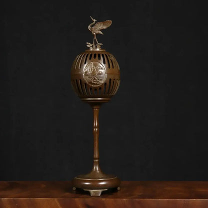 Antique bronze crane incense burner with spherical body, vertical slits, engraved landscape, and detailed crane figurine decorbites incense burner