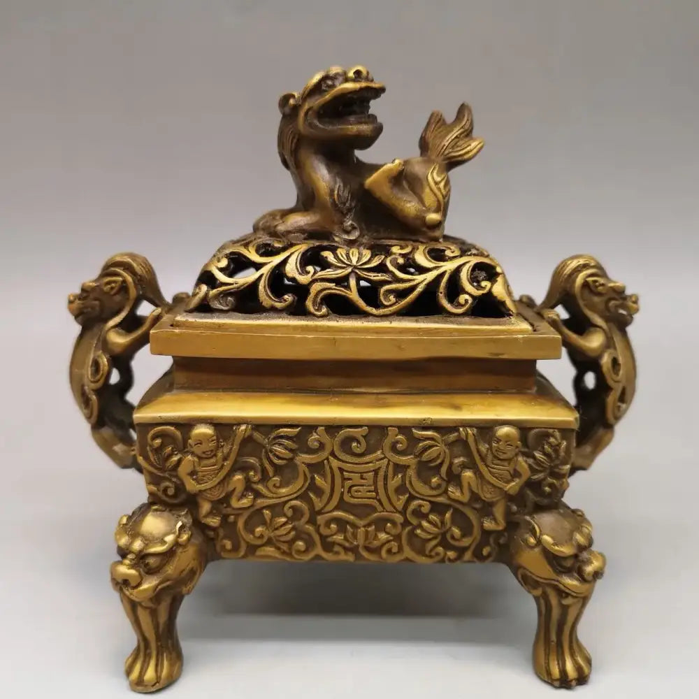 Golden brass incense burner with double dragon lion motifs and ornate filigree lid featuring a mythical beast holding fish