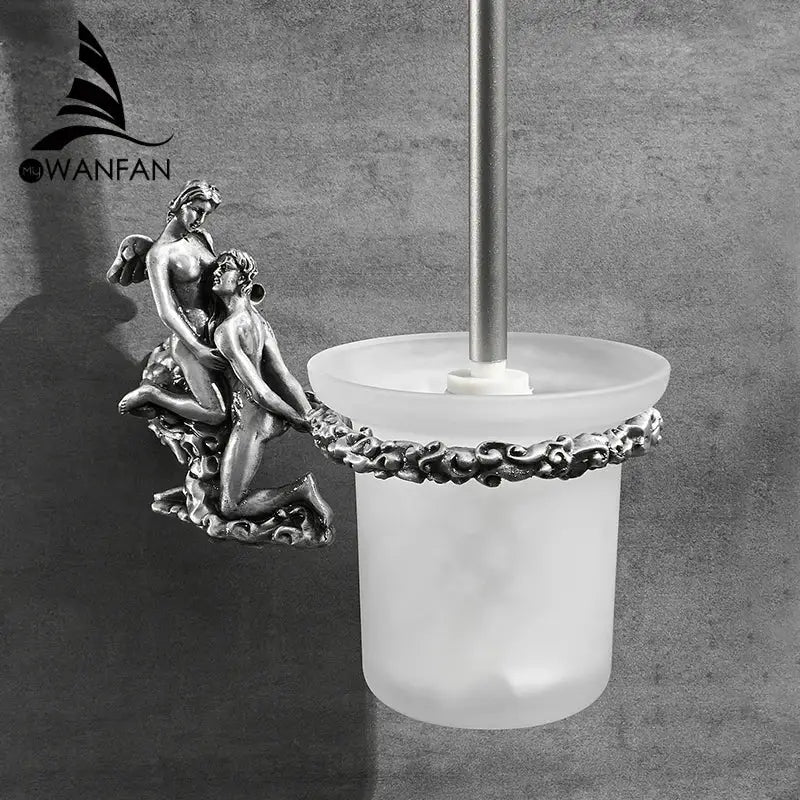Silver-toned toilet brush holder with frosted glass base and intricate entwined figures in antique cherub design