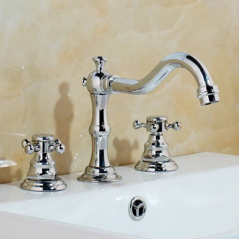 Antique chrome and black decorbites dual handle basin faucet with curved spout and ornate three-handle design