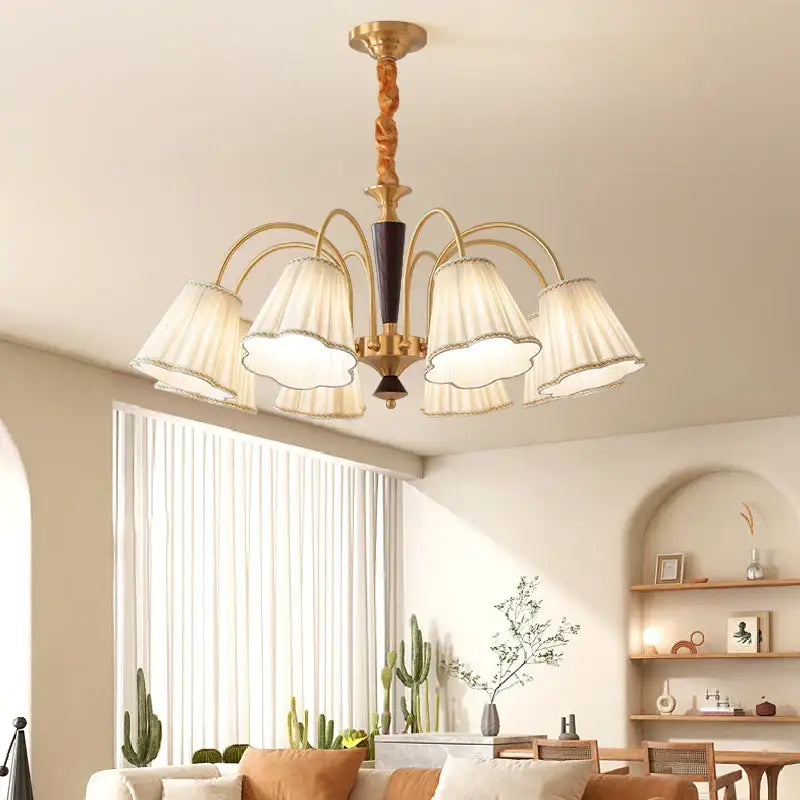 Antique copper chandelier with gold-toned finish, twisted wooden stem, and five cream pleated fabric shades for dining room