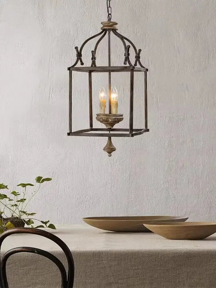 Antique dark bronze wrought iron chandelier light with glass panels and three glowing candle bulbs by decorbites creative american iron