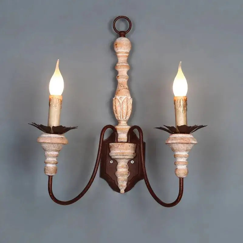 Antique double head french wall lamp with distressed white wood finish and dark metal accents featuring two candle bulbs