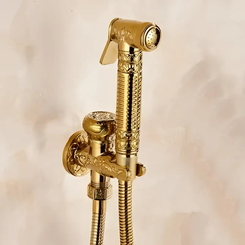 Gold-colored ornate brass bidet shattaf with engraved handle and textured hose for bathroom hygienic washing